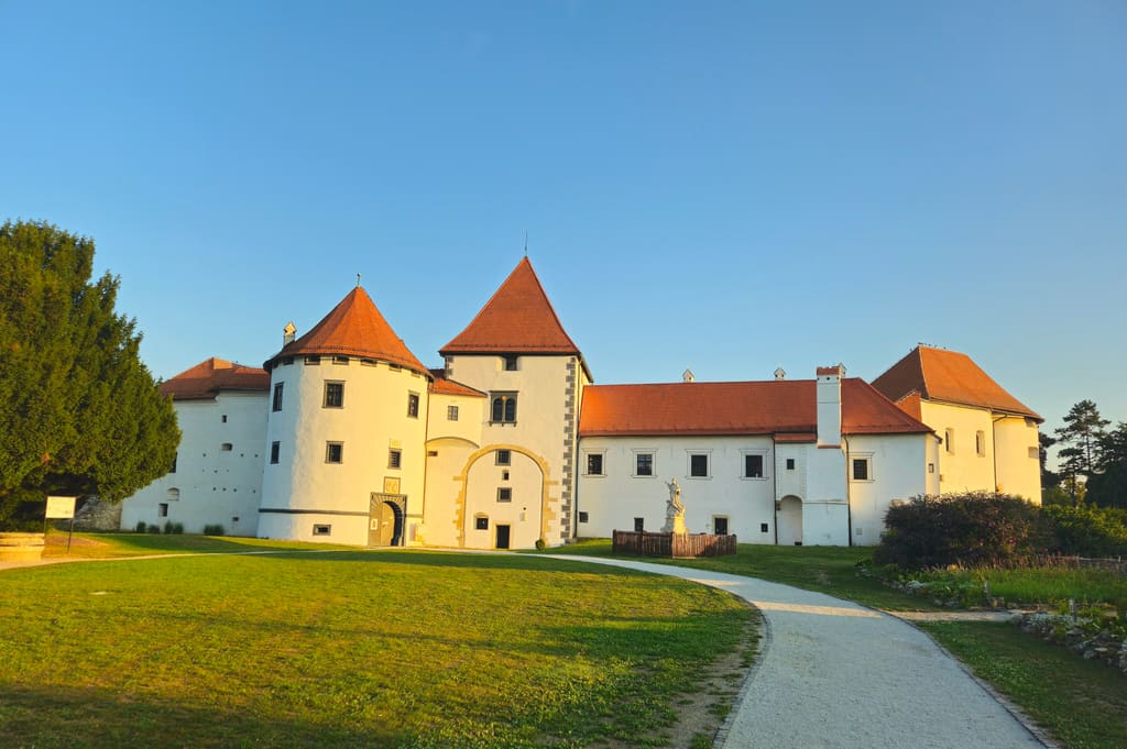 Varaždin Old Town, a white fortress with red roofs beyond a lawn